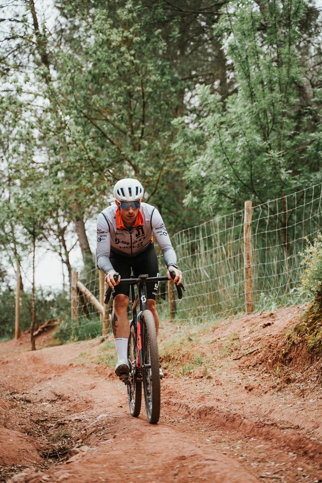 Atleta in salita su Gravel seguito da Giovanni